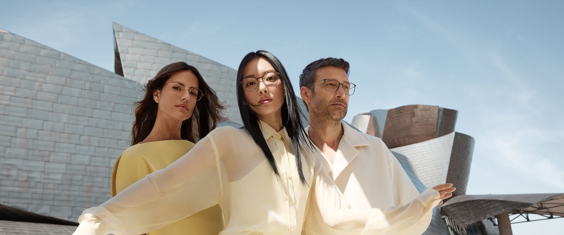 Three people wearing Silhouette optical glasses in front of the Guggenheim Museum in Bilbao, campaign photograph
